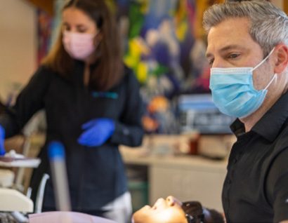 man with dental assistant looking at smile